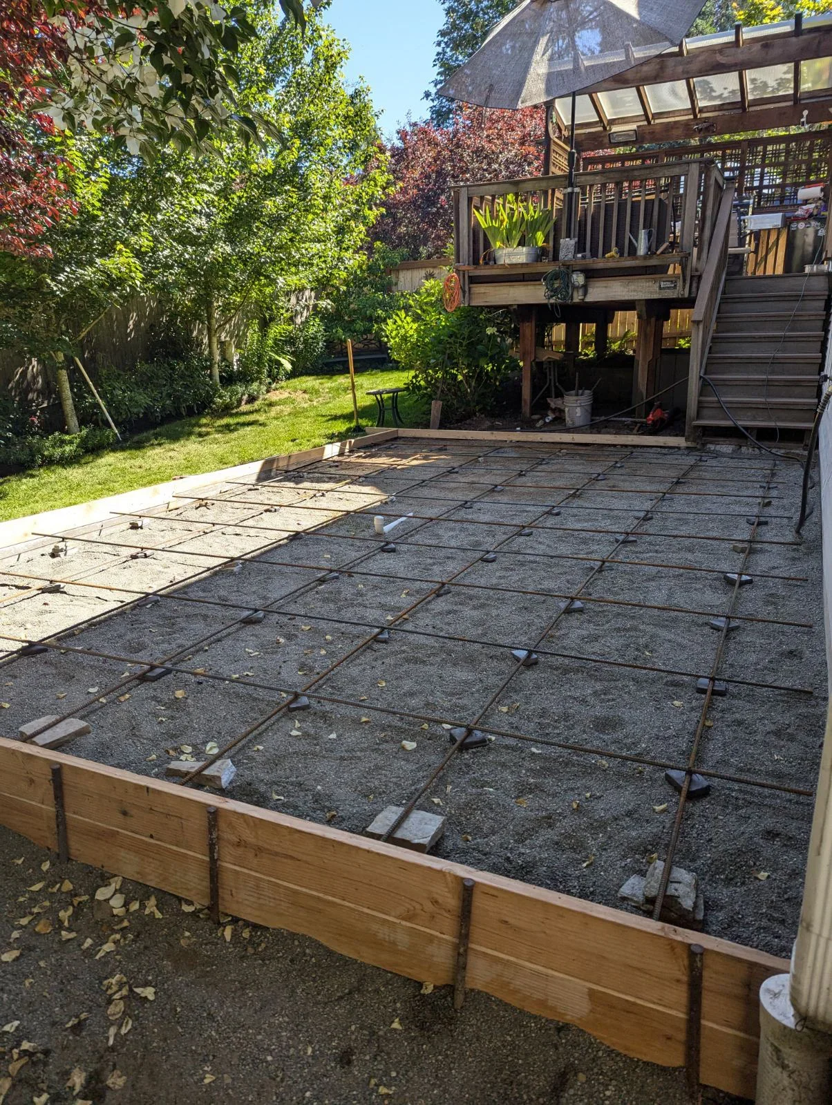 Reinforced concrete pad with rebar grid and wooden frame border during installation