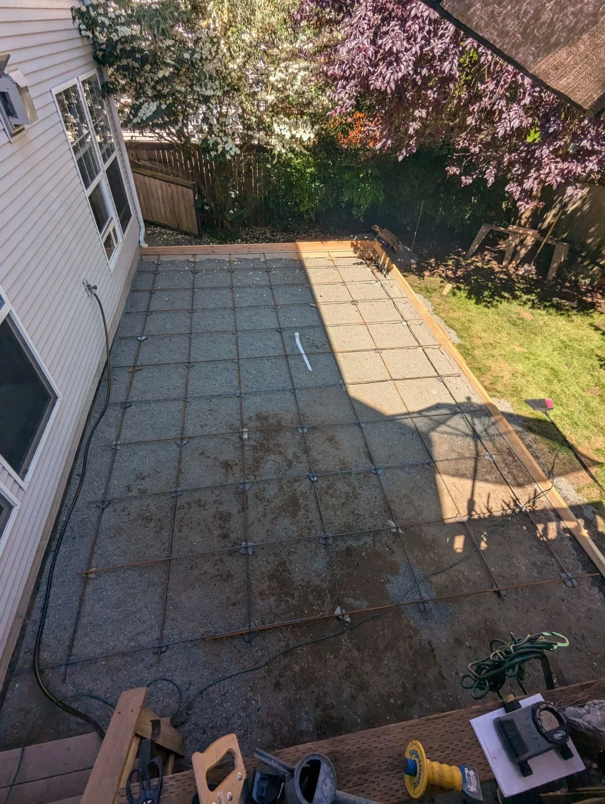 Concrete patio with laser leveling equipment and repair work in progress