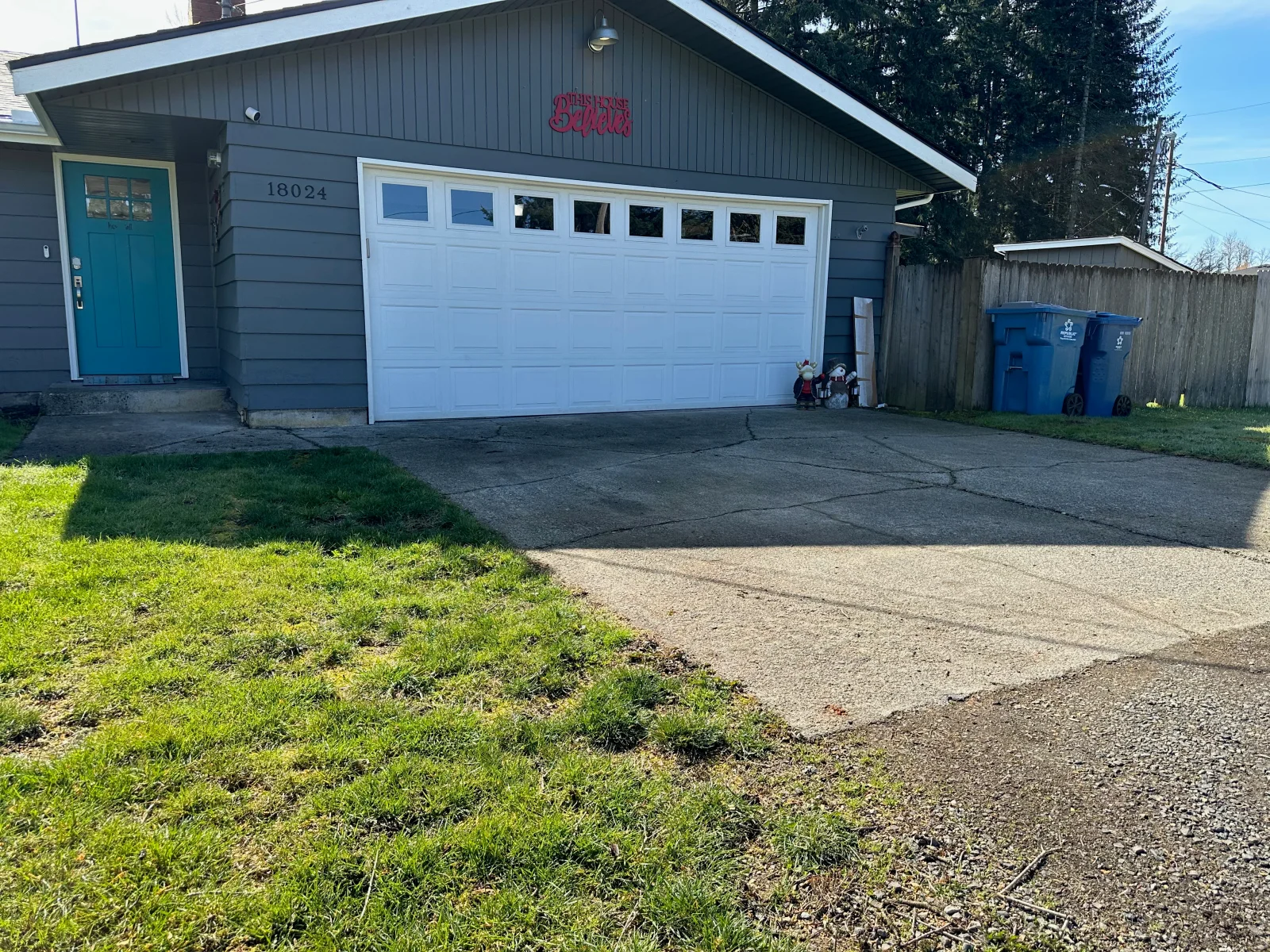 New concrete driveway in front of residential garage with white overhead door