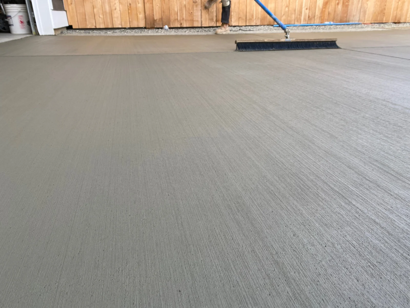 Newly poured concrete driveway with broom finish texture and directional scoring