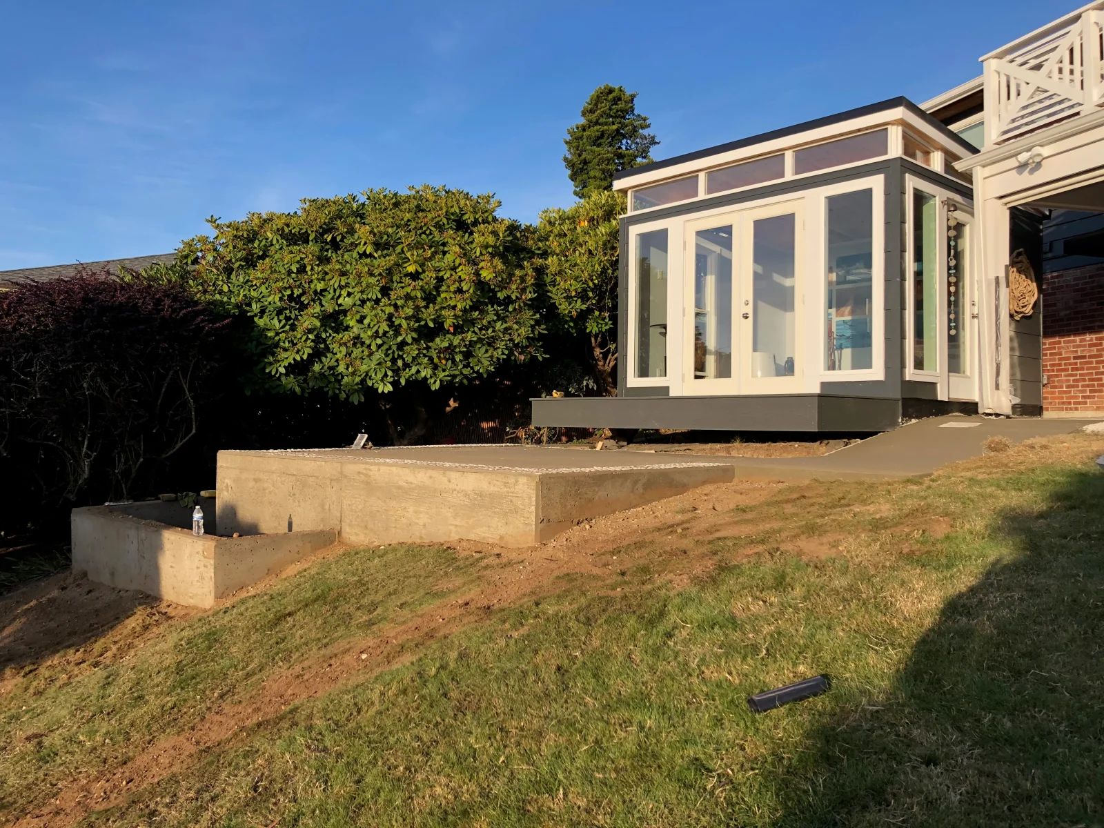 Concrete foundation pad and base for sunroom addition with proper grading