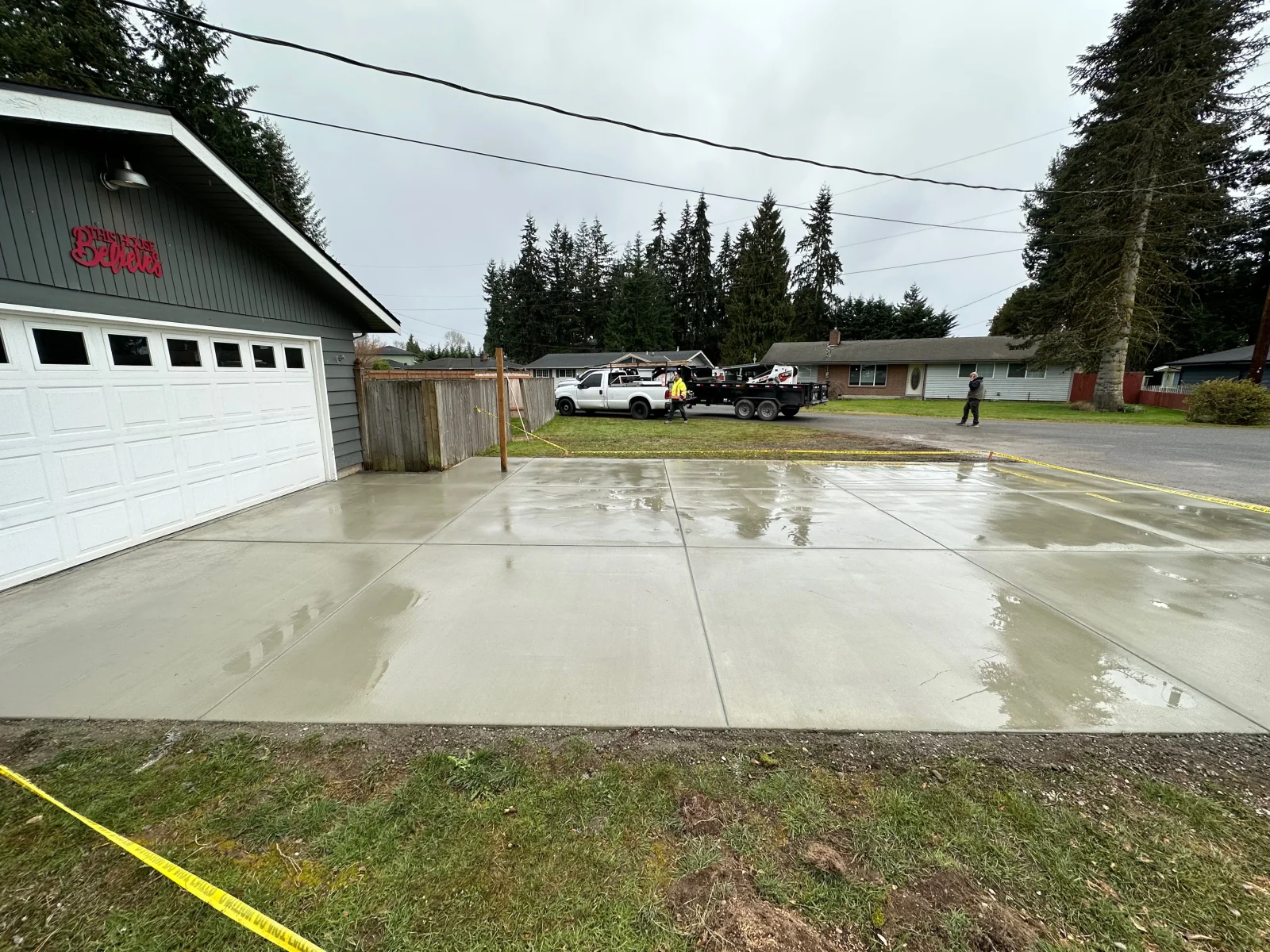 Newly poured concrete driveway with control joints, wet finish, residential setting