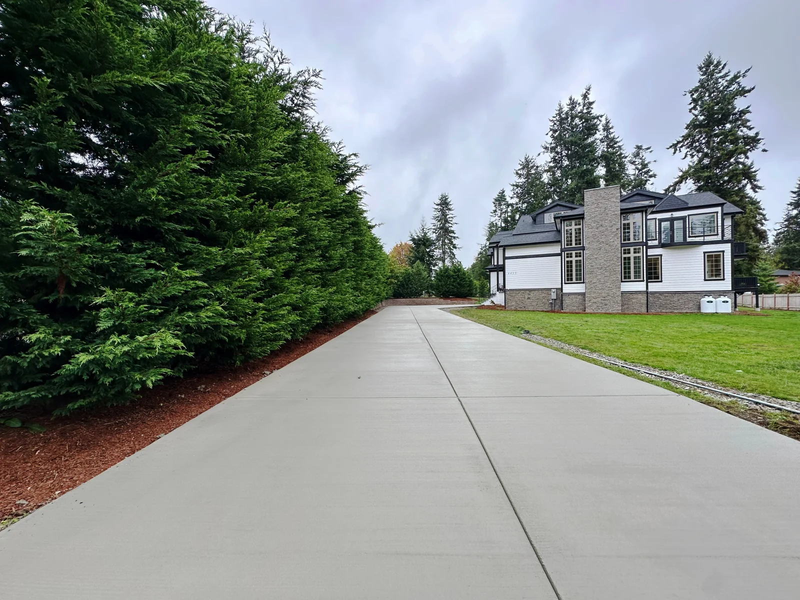Concrete driveway with broom finish and control joints leading to modern home