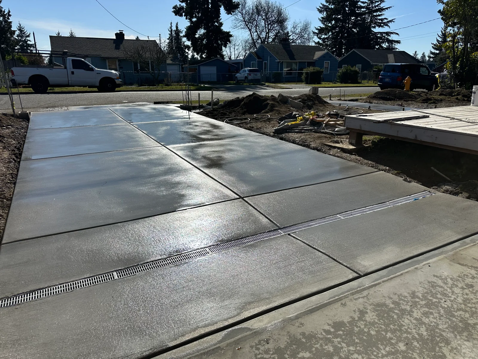 Freshly poured concrete driveway with control joints and linear drainage channels installed