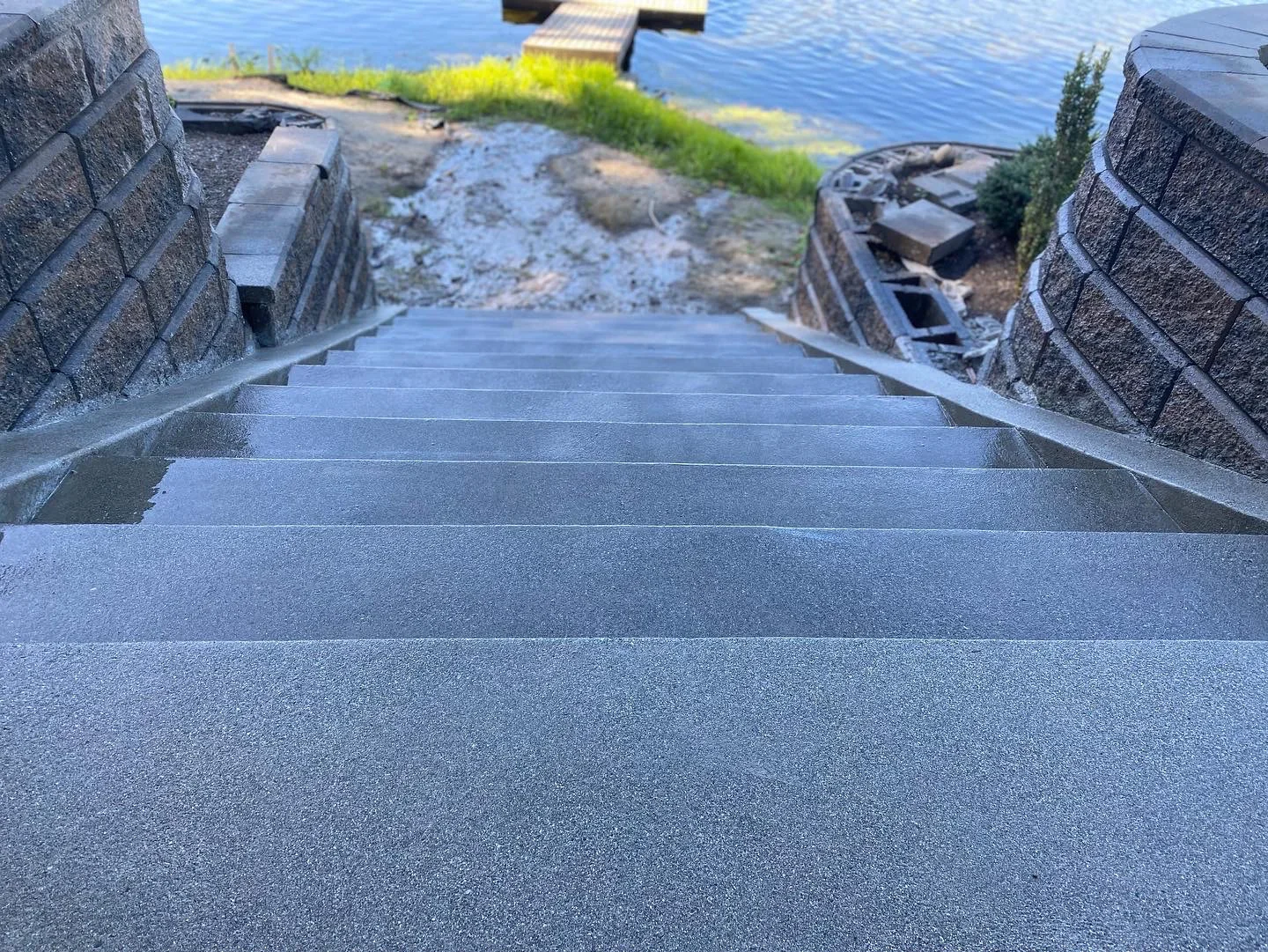 Concrete steps with sand finish between granite retaining walls leading to waterfront